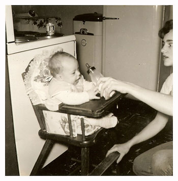 Olive feeding baby in highchair