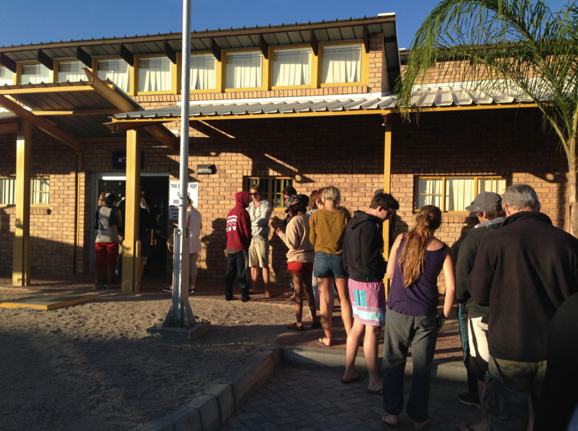 Students stand in line waiting to enter a building before they cross the border to Namibia.