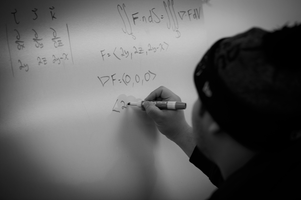 solving a math problem writing by hand on a whiteboard