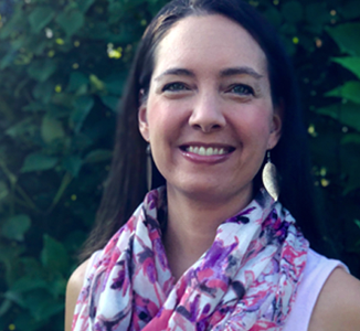 A headshot, taken by her daughter, depicts
                    Jessica smiling and wearing a bright scarf outside.