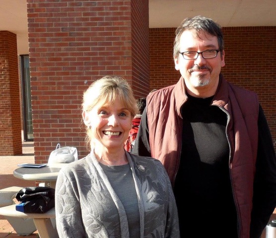 photo of smiling, white woman and taller, white man wearing glasses