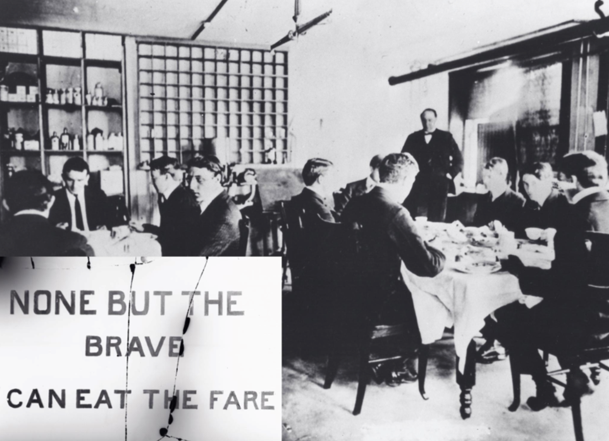 A black and white photograph of the 'Poison Squad' male volunteers seated and dining at two tables, with Dr. Wiley standing in the back corner, hands in pockets, gazing on.