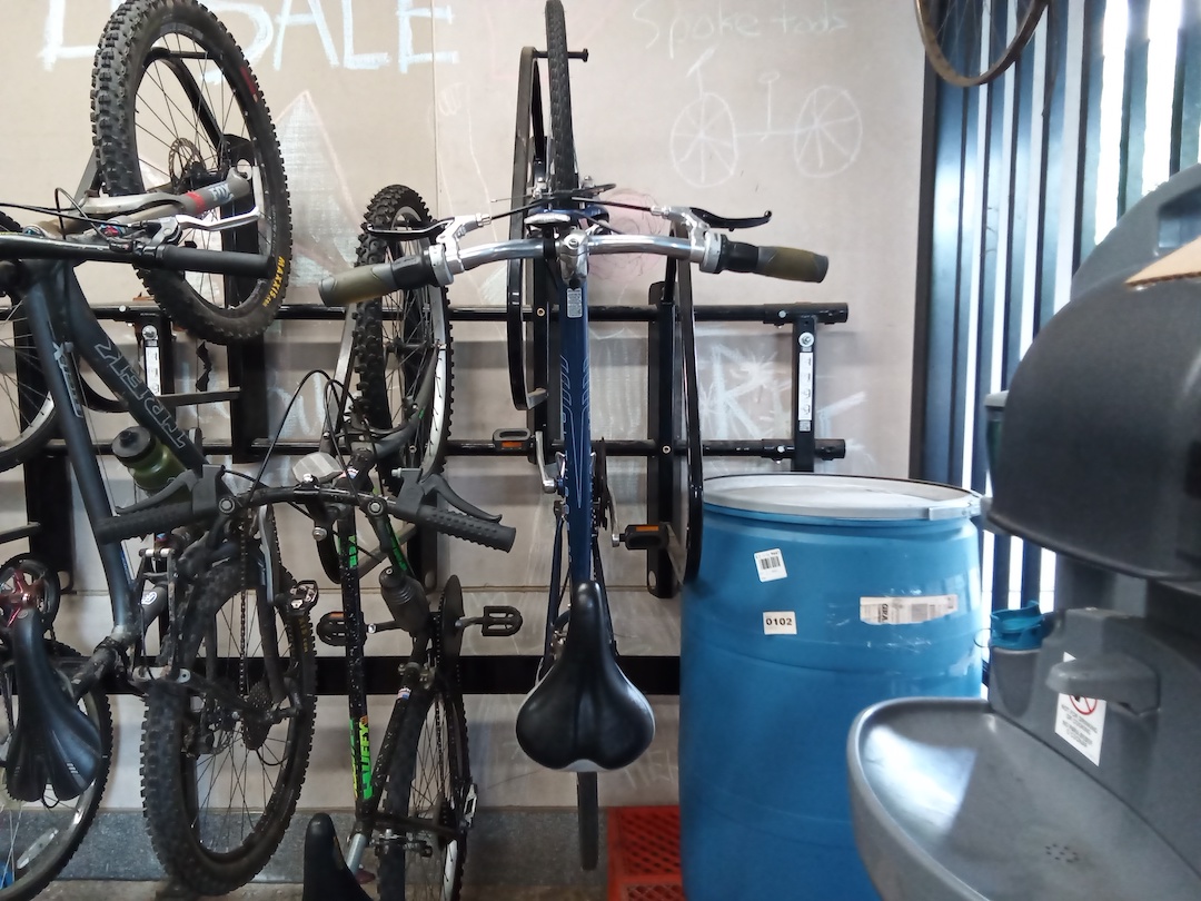 Bikes hang from the wall at the bike re-use store. 